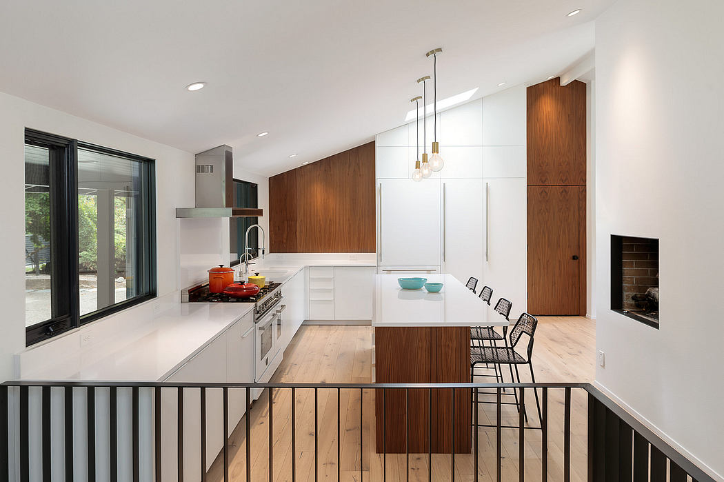A spacious, modern kitchen with sleek white cabinets, warm wood accents, and pendant lighting.