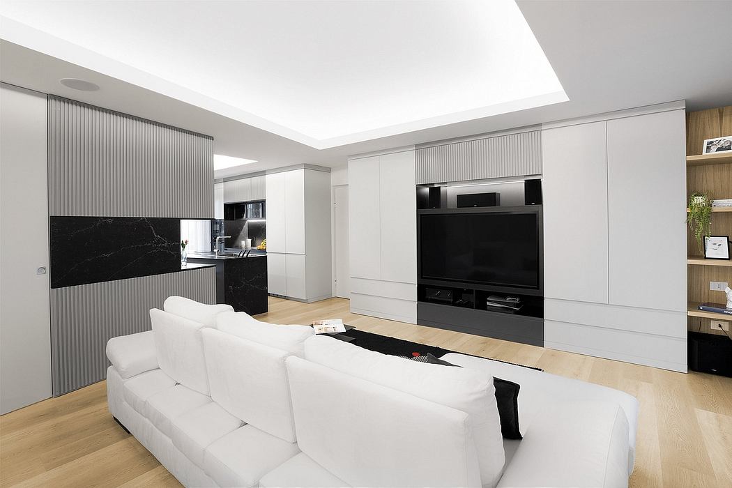 Sleek, modern kitchen and living room with clean lines, white furniture, and black accents.