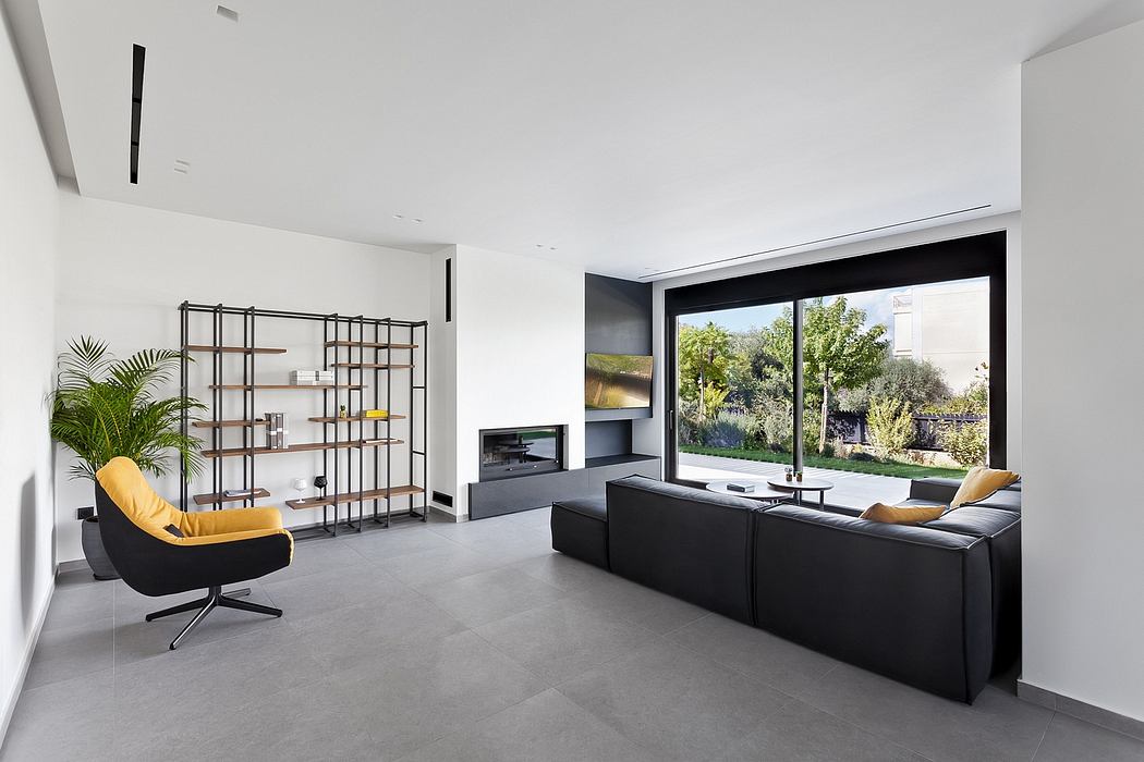 Spacious modern living room with minimalist furniture, large window, and sleek black accents.