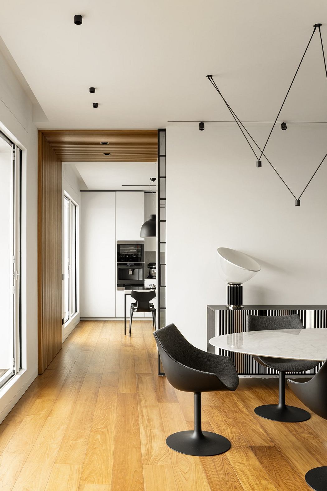 Contemporary open-plan living space with minimalist, geometric lighting and furnishings.