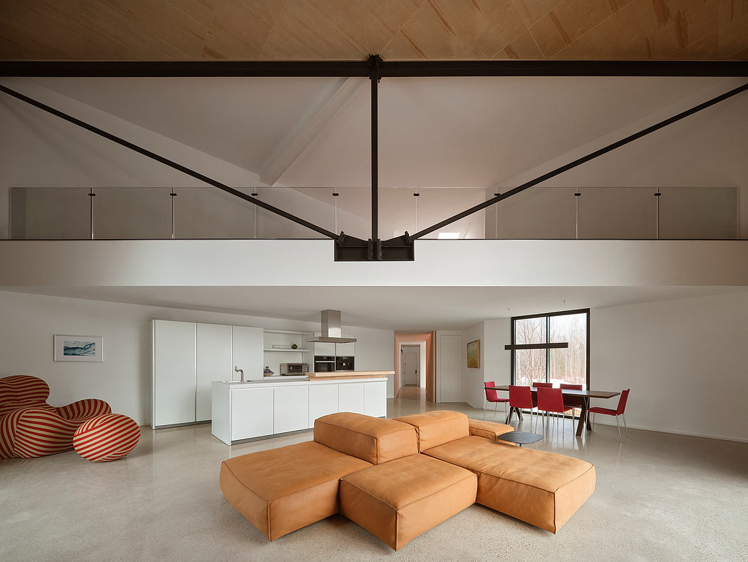 Spacious open-concept living area with modern lighting, minimalist furnishings, and exposed ceiling beams.