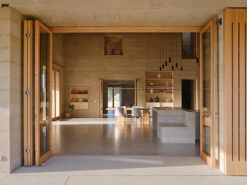 Expansive open-plan space with wood-clad walls, concrete floor, and minimalist furnishings.