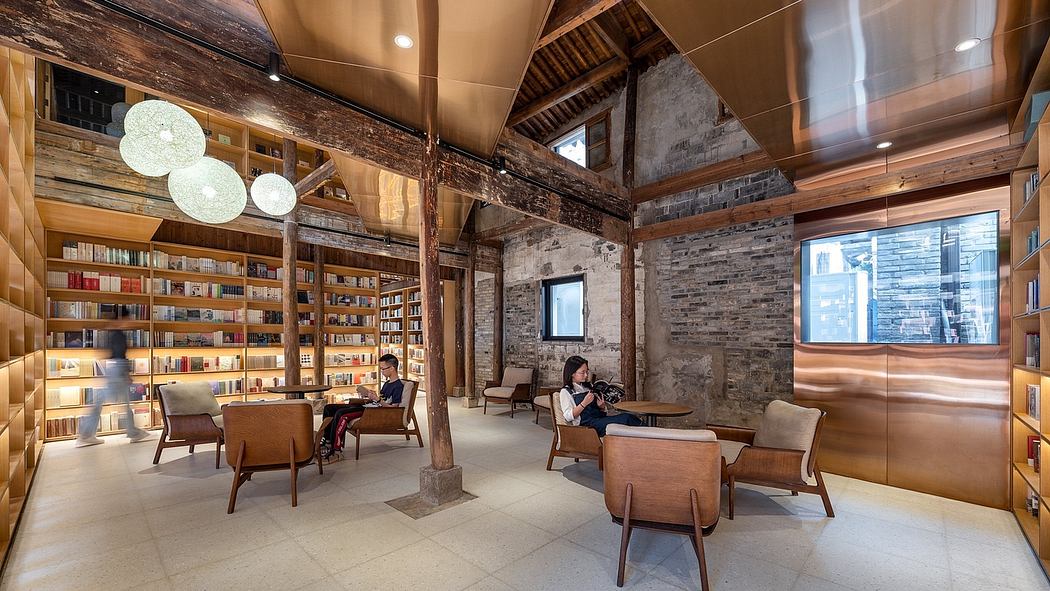 A cozy, warm library with exposed wooden beams, brick walls, and comfortable seating.