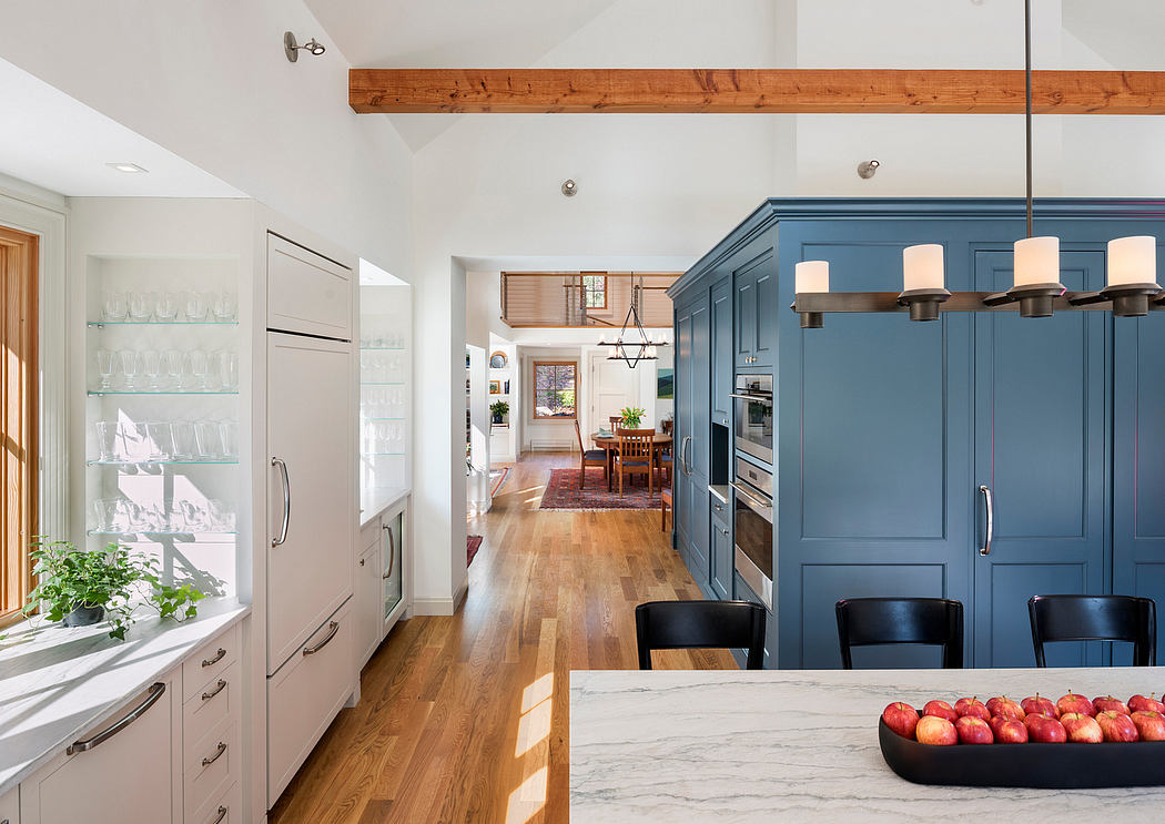 Rustic-inspired kitchen with modern blue cabinetry, marble countertop, and wood beams.