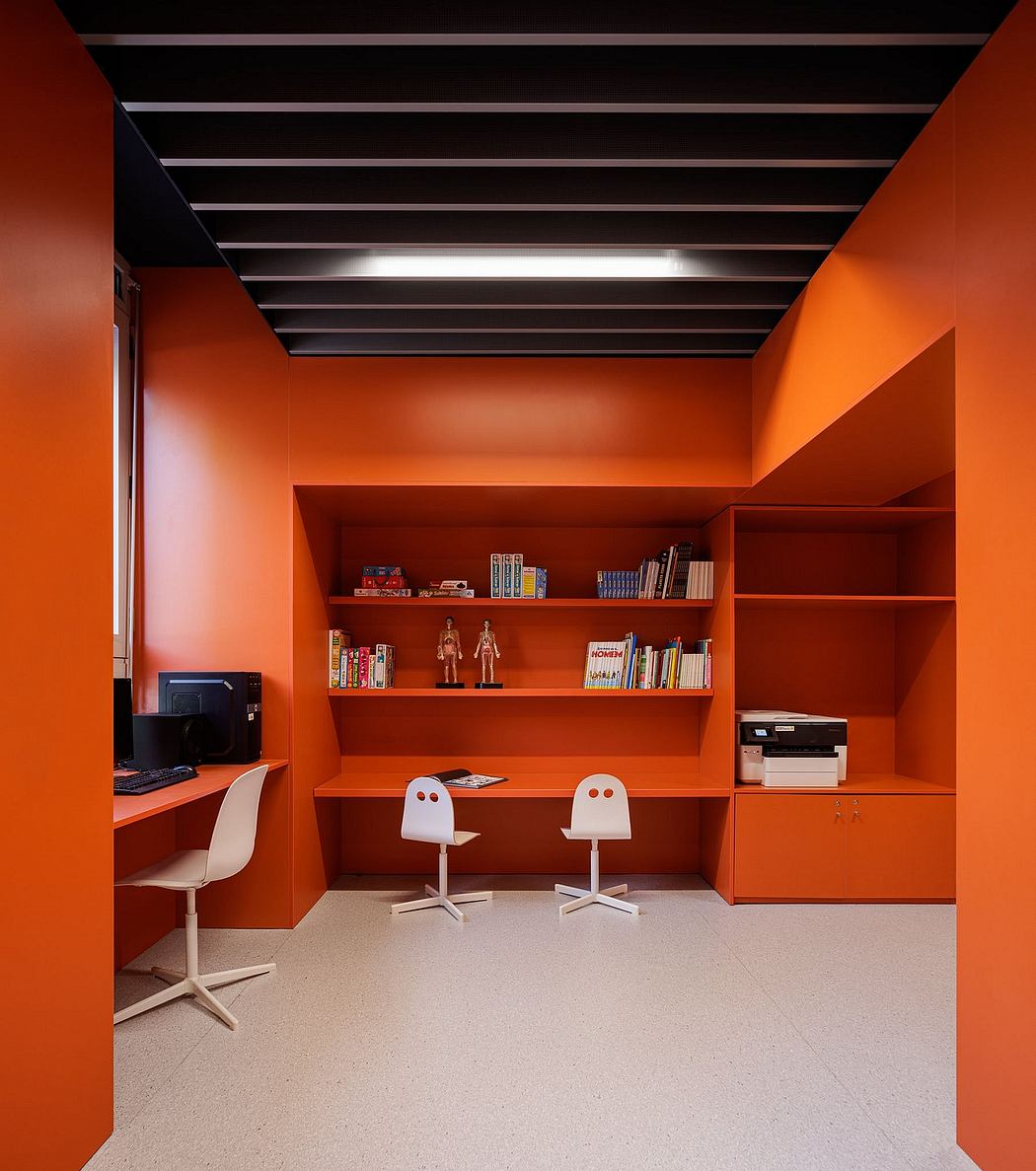 A vibrant, contemporary office space with bold orange walls, built-in shelves, and minimalist furnishings.