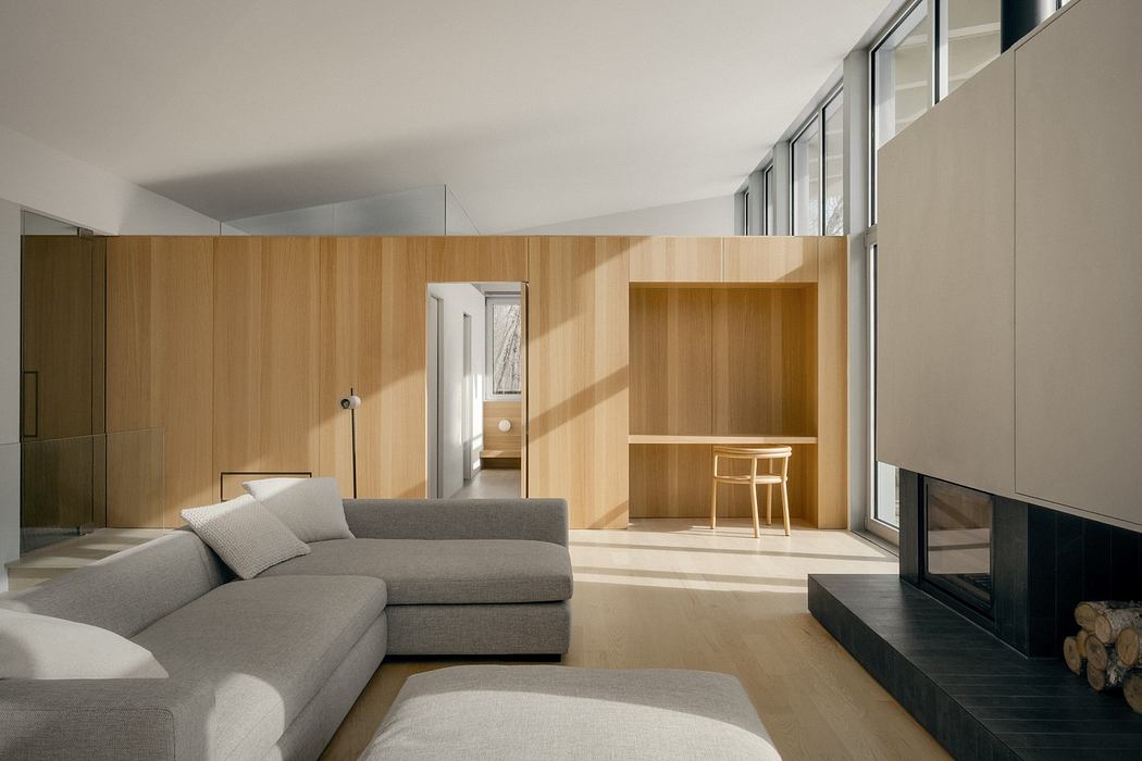 Spacious living room with wooden panel walls, large windows, and a fireplace.