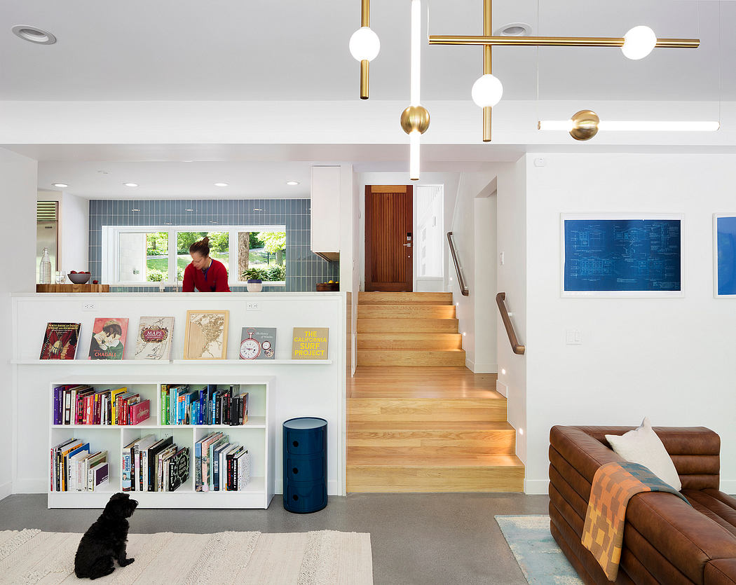 Modern home interior with sleek lighting fixtures, wooden stairs, and built-in bookshelves.