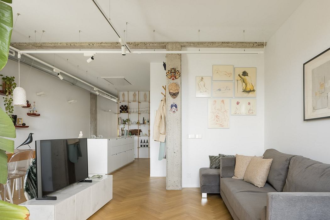 An open-concept living space with exposed concrete beams, white walls, and custom built-in storage.