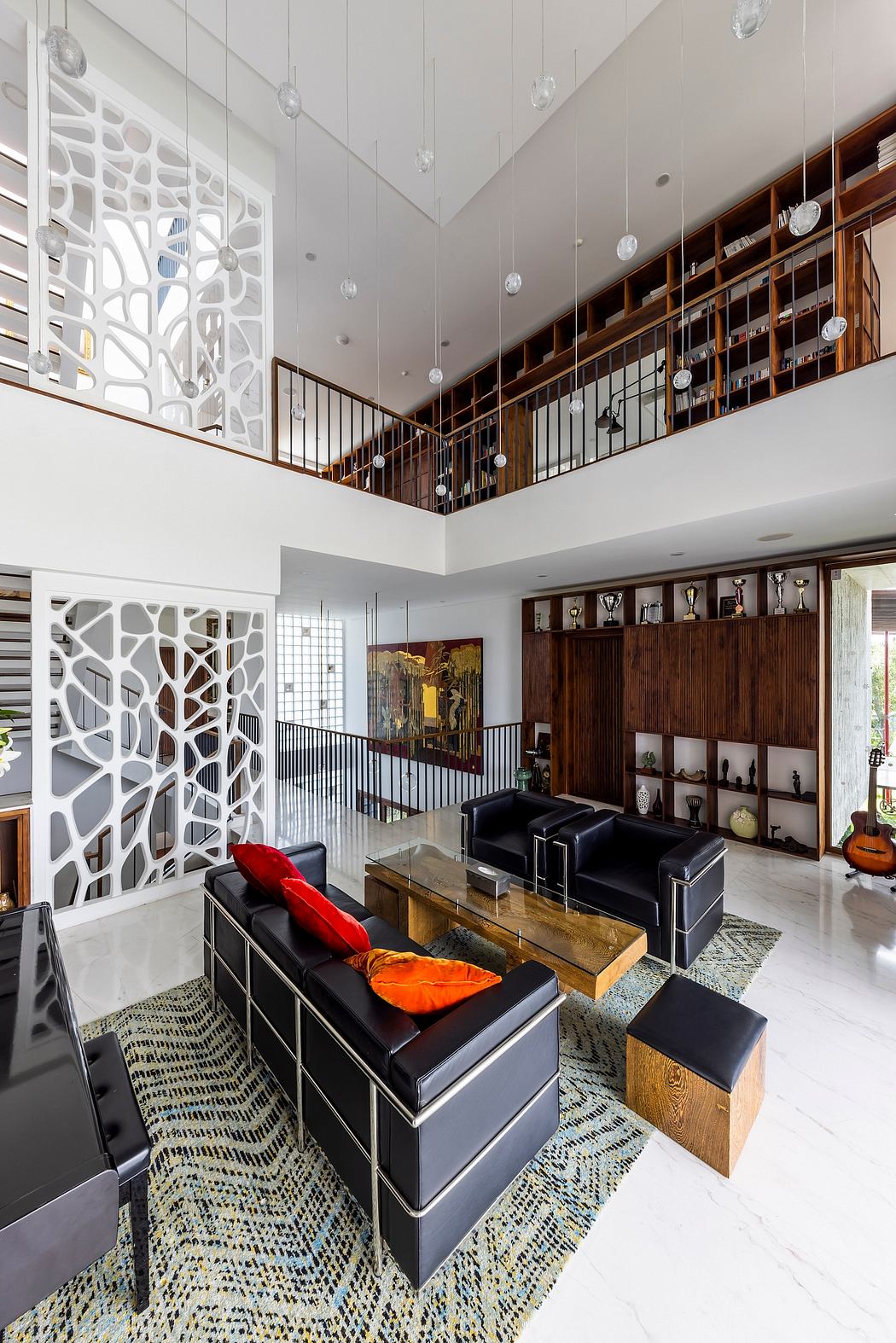 Expansive living room with modern lighting, intricate wall patterns, and built-in shelving.