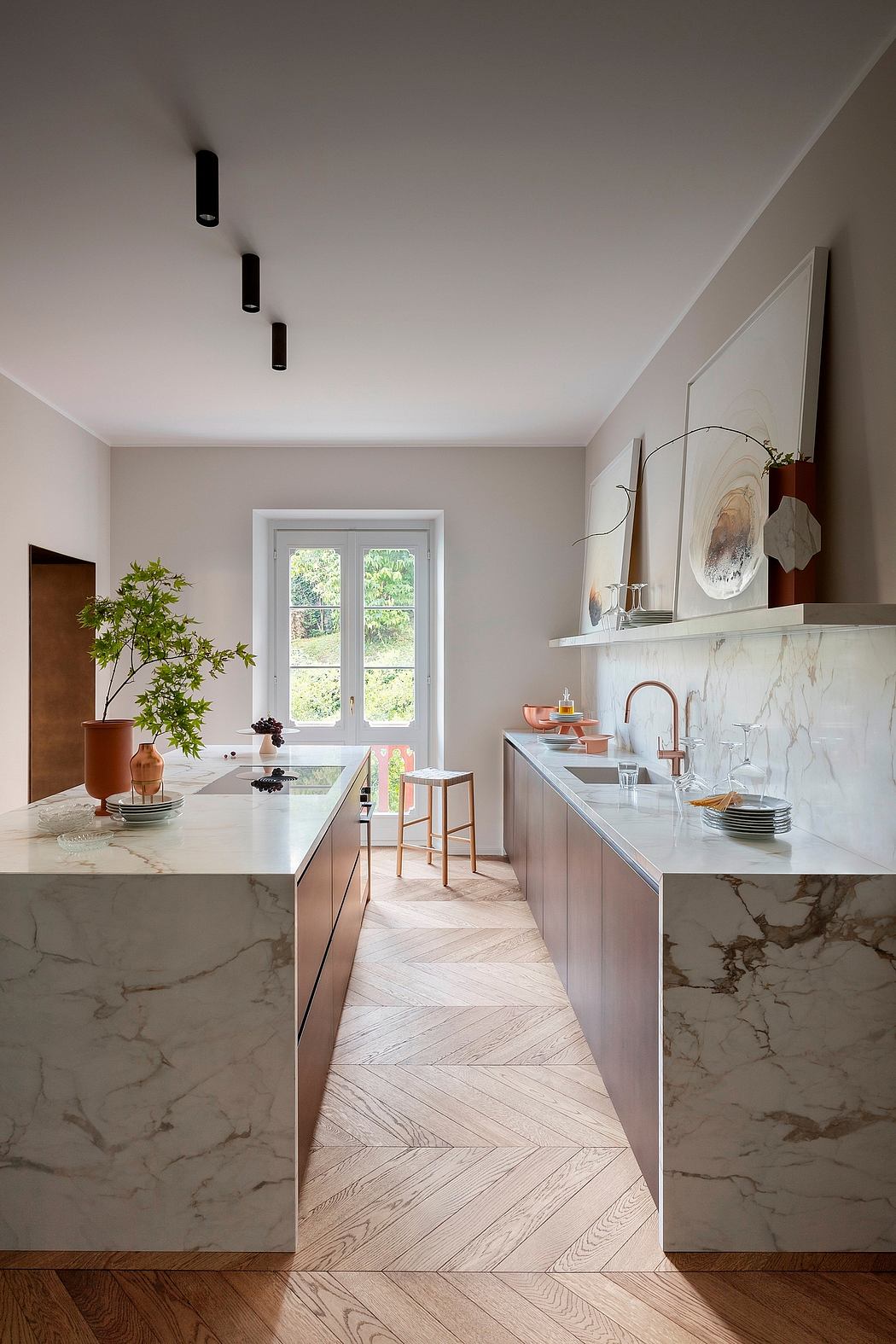 Sleek kitchen with marble countertops, herringbone floors, and modern lighting.