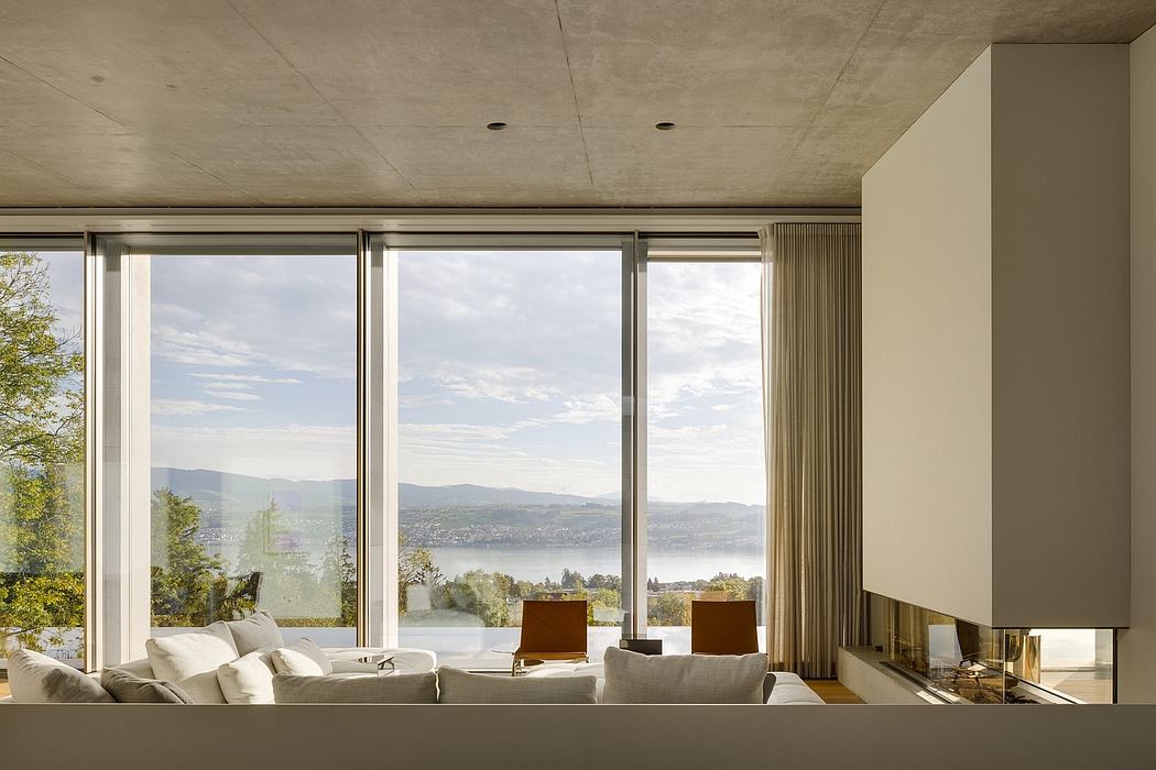 Expansive windows frame a scenic lakeside view, complemented by a minimalist, contemporary design.