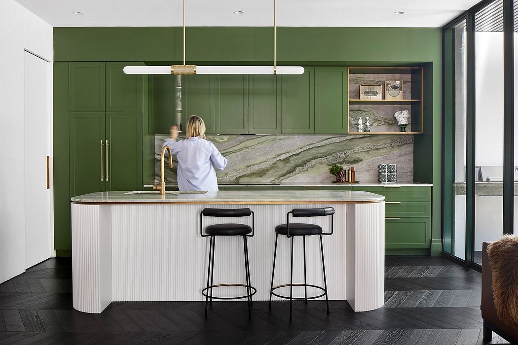 Sleek, modern kitchen with contrasting green cabinetry and a striking marble backsplash.