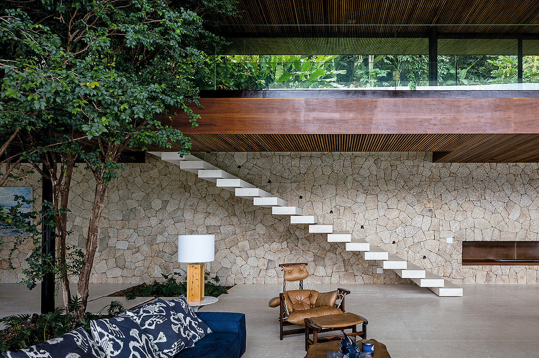 Rustic stone wall, wooden beams, and floating staircase create an elegant indoor-outdoor space.