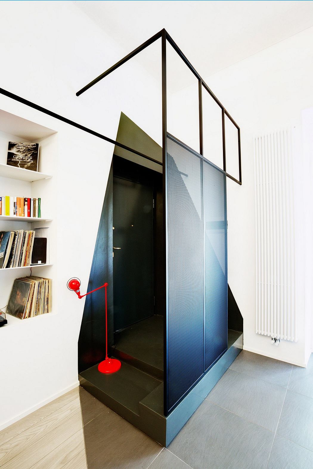 Striking geometric entryway with bold black frames, glass panel, and red lamp.