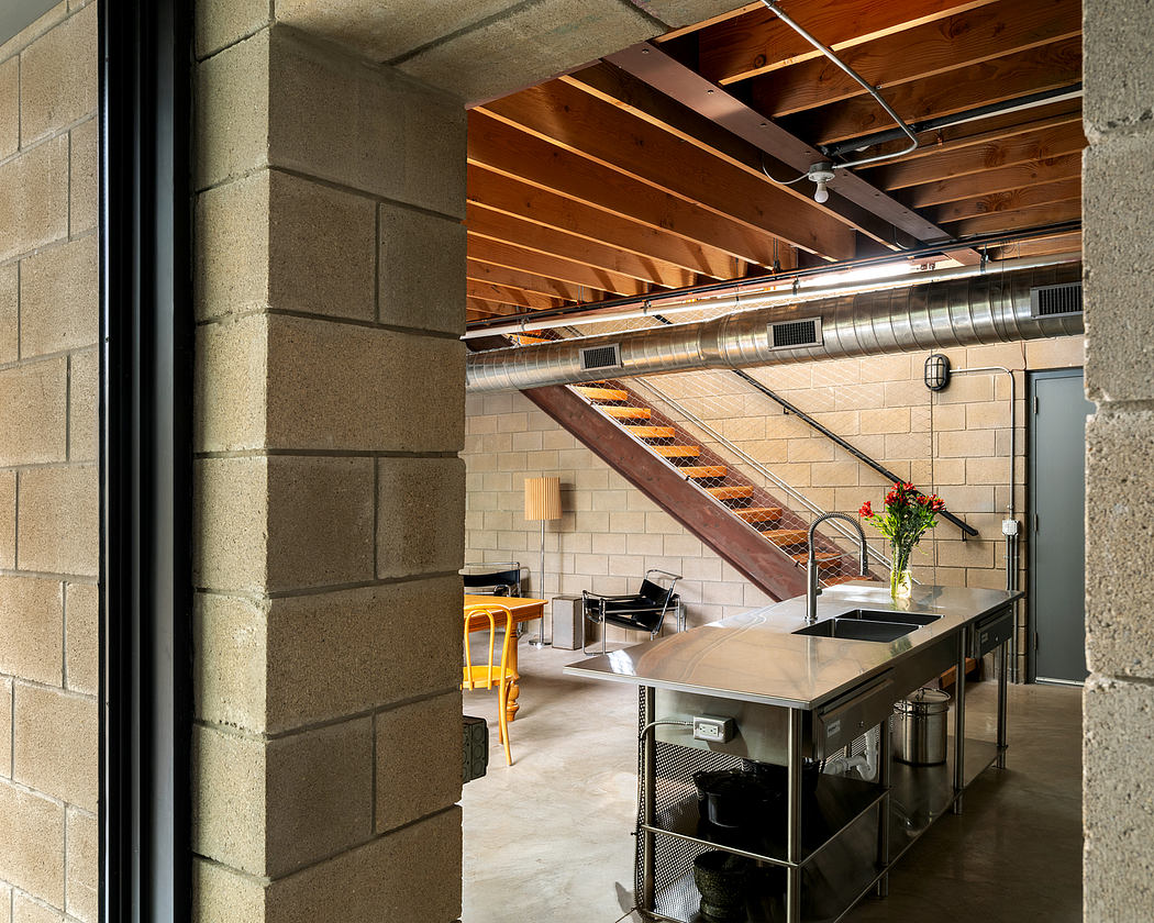 A modern, open-concept kitchen with exposed wooden beams, stainless steel appliances, and a central island.