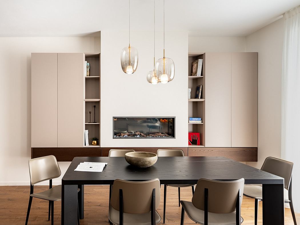Minimalist dining room with sleek built-in shelving, pendant lights, and a dark wood table.