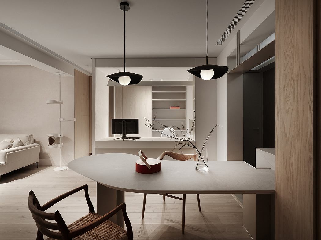 Minimalist living room with a round table, pendant lights, and built-in storage.