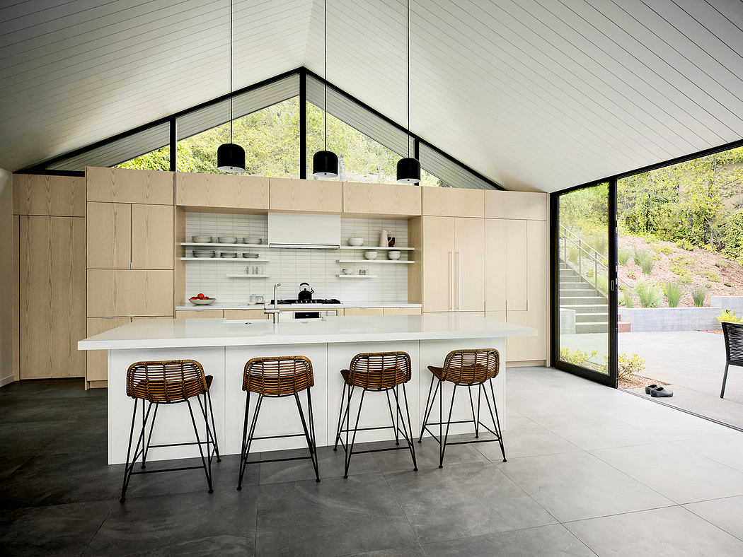 Bright, modern kitchen with sleek cabinetry, minimalist bar stools, and panoramic windows.