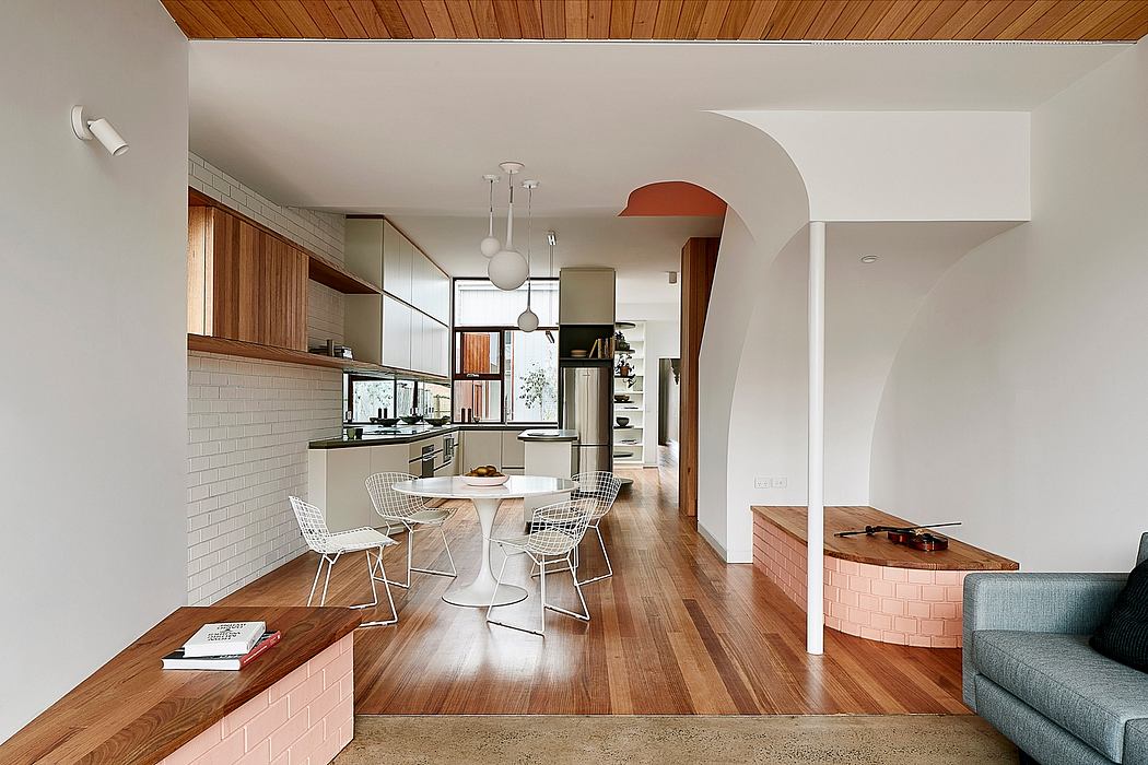 Sleek, modern kitchen with warm wood accents, subway tile backsplash, and curved archway.