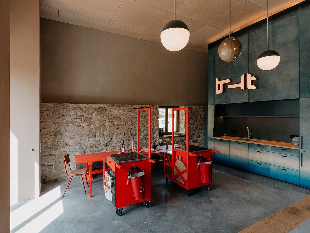 A modern kitchen with red mobile workstations, exposed stone walls, and globe pendant lights.