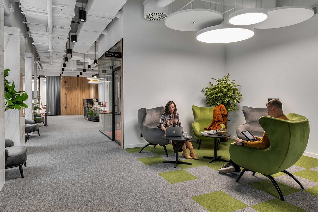 A modern, open-concept office space with gray tones, plush seating, and greenery accents.