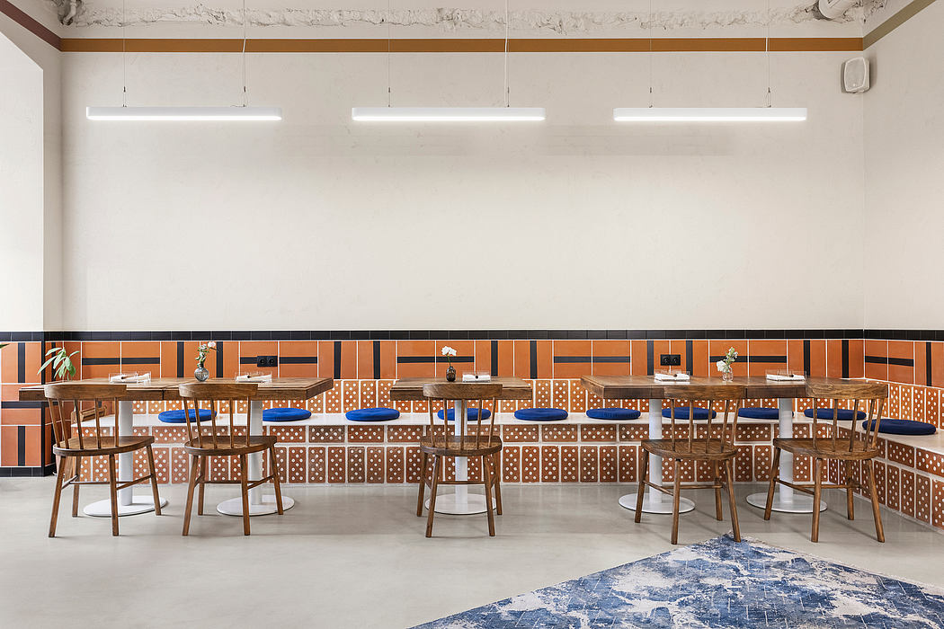 The image depicts a stylish and modern cafe or restaurant interior, with geometric tile patterns, wooden furnishings, and a clean, minimalist design.