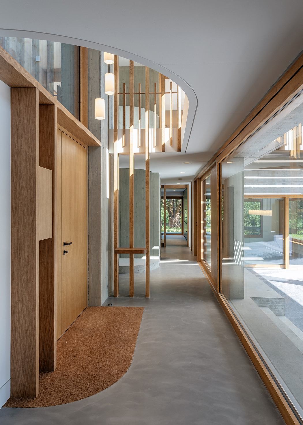A modern, spacious interior with wooden accents, a curved partition, and recessed lighting.