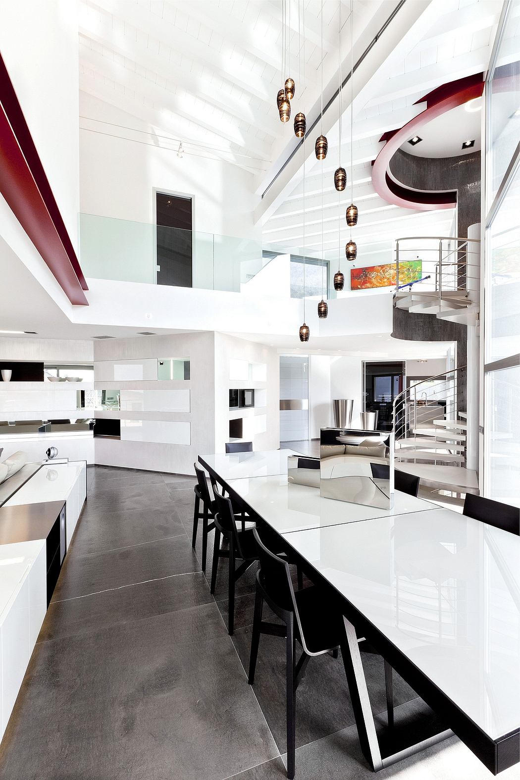 A sleek, modern kitchen with high ceilings, pendant lighting, and a minimalist design aesthetic.