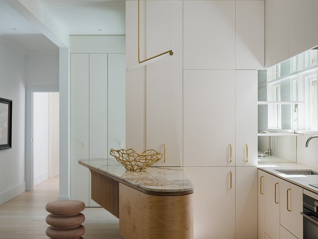 Elegant kitchen with sleek cabinetry, marble countertop, and modern gold accents.