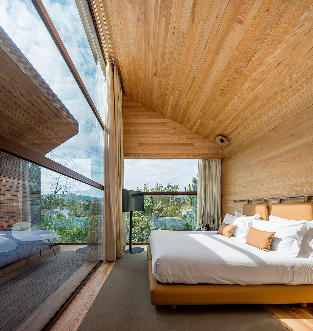 Spacious wood-paneled bedroom with large windows offering a scenic view of the outdoors.