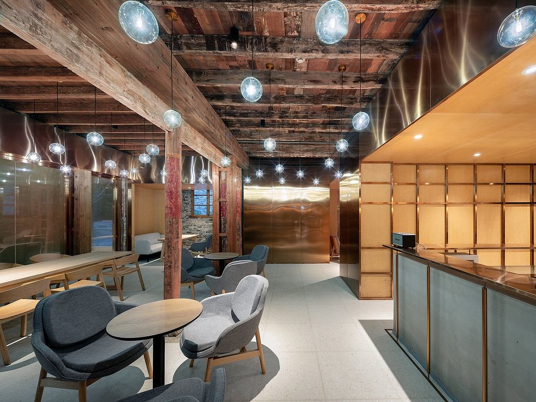 Warm lighting illuminates wood-paneled ceilings and modern furniture in this inviting space.