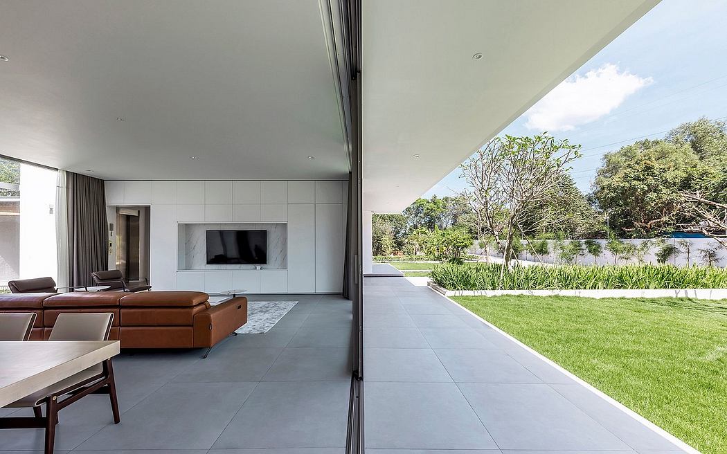 Spacious living room with minimalist decor, large windows, and lush outdoor views.