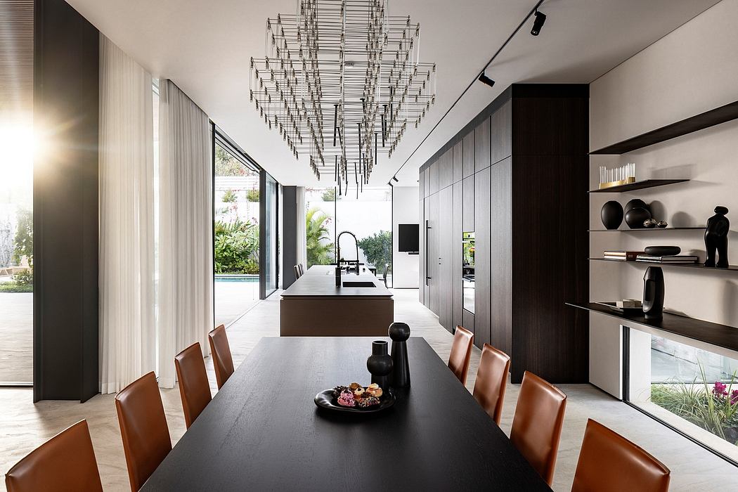 Striking modern interior with sleek black furnishings, dramatic chandelier, and expansive windows.