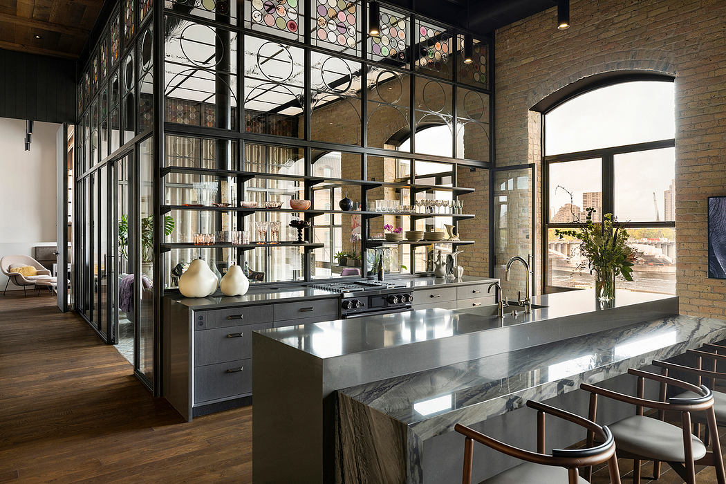 An industrial-style kitchen with a sleek marble counter, open shelving, and arched windows.