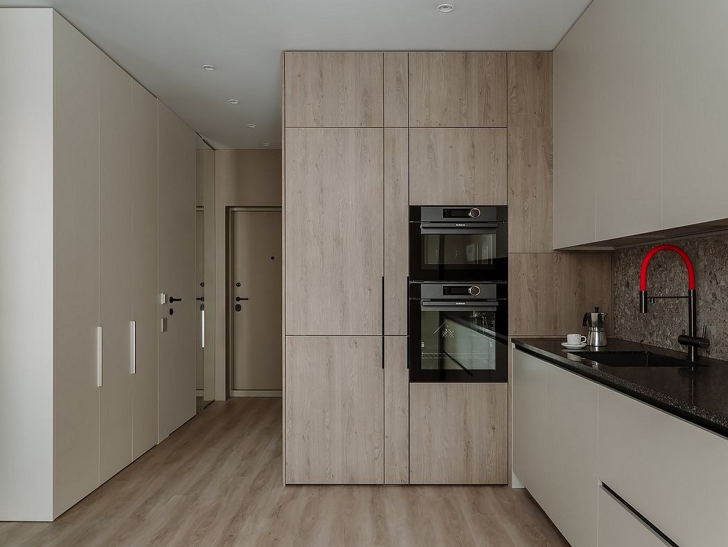 Modern kitchen with sleek cabinetry, built-in ovens, and dark countertop.