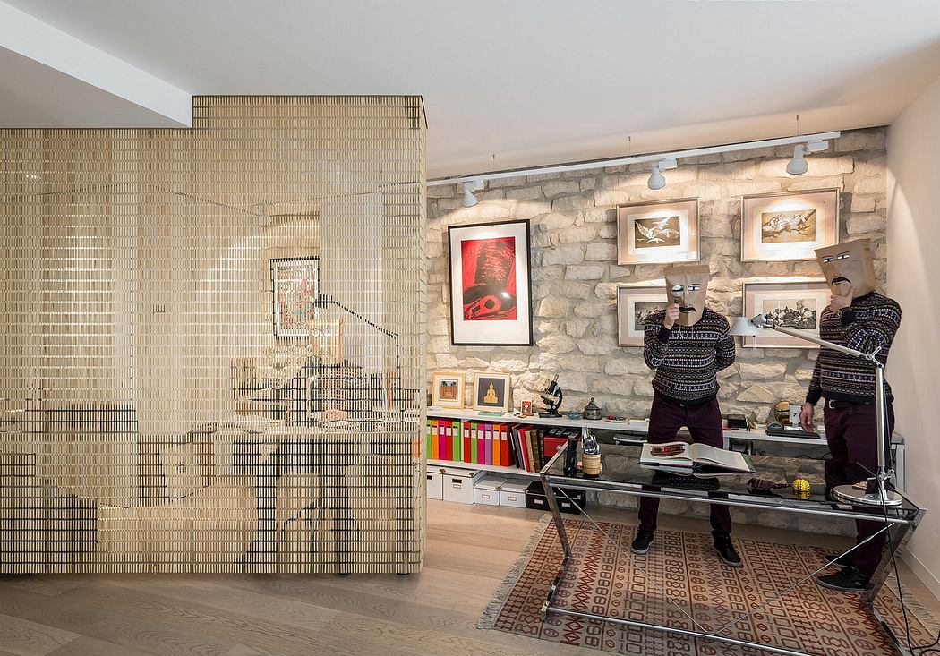 The image shows an interior design with a stone wall, shelves, and framed artwork. The space has a modern and industrial aesthetic.