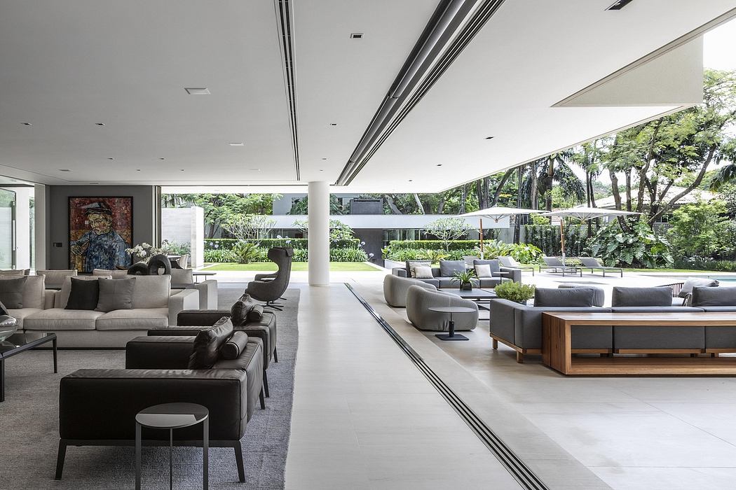 Spacious, modern interior with sleek furniture, large windows, and lush surrounding greenery.