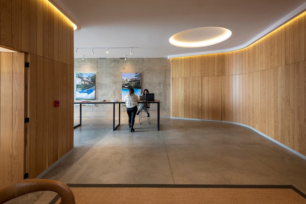 Sleek, minimalist office space with concrete floors, wood paneled walls, and modern lighting.