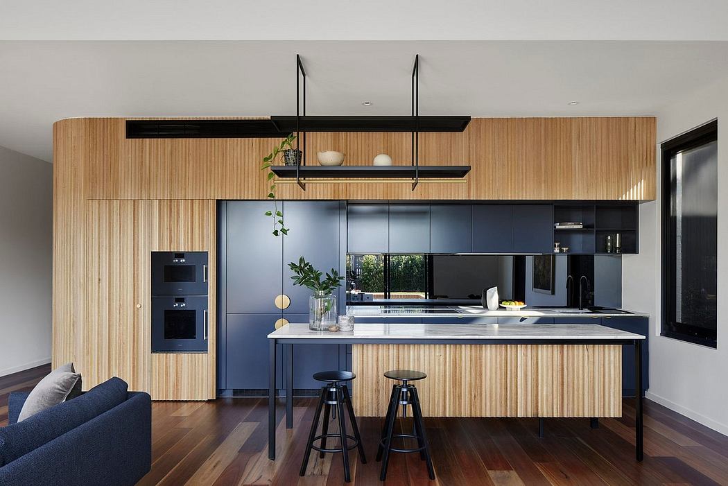 Modern kitchen with sleek black cabinetry, wooden walls, and minimalist shelving.