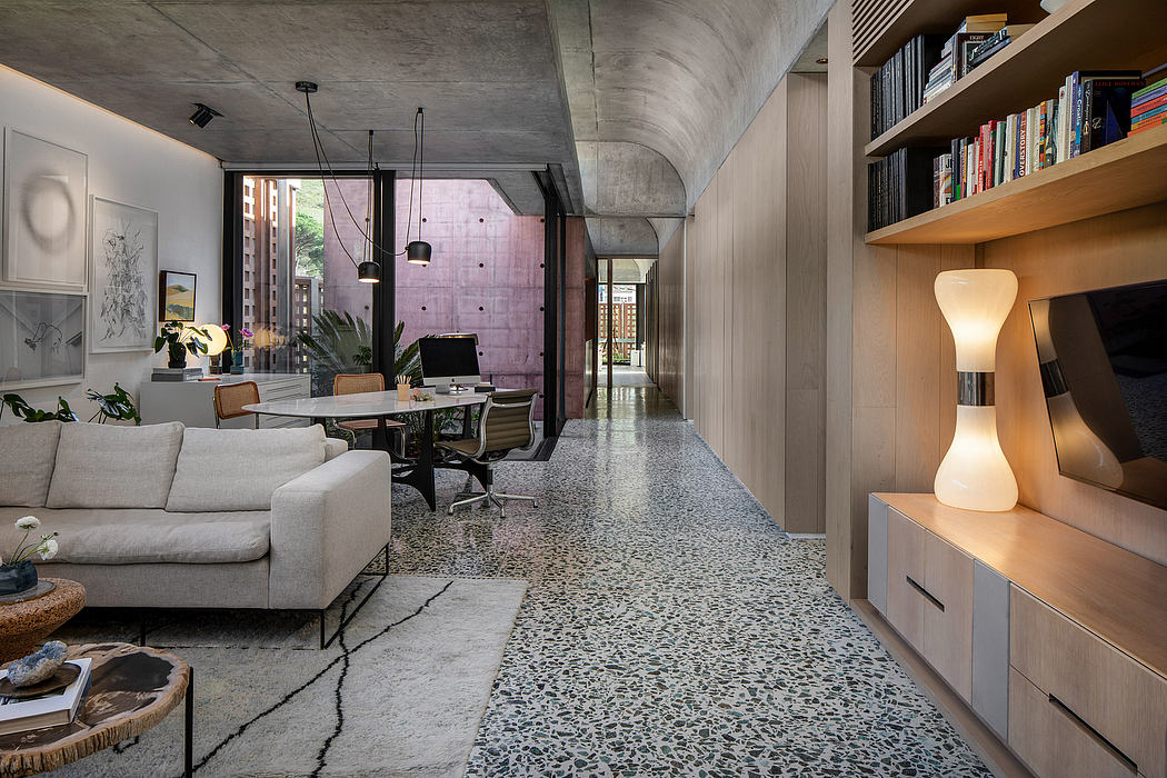Spacious loft-like living area with concrete ceilings, built-in shelving, and modern furnishings.