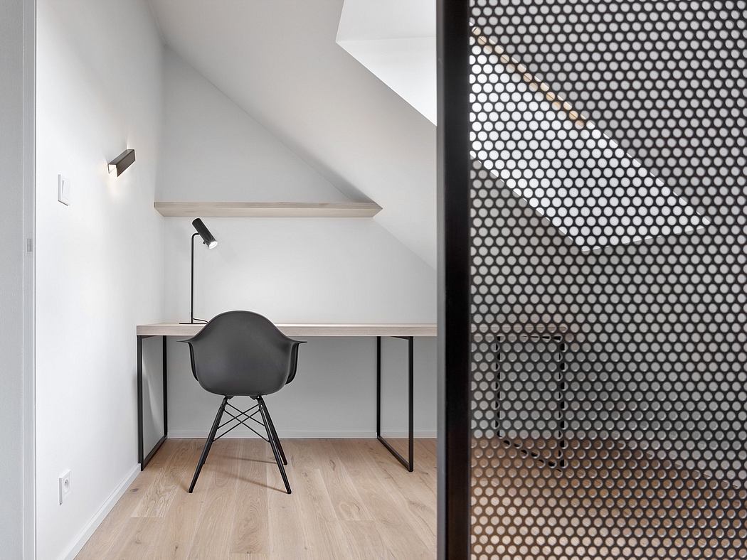 Minimalist workspace with black chair, floating shelves, and patterned screen divider.