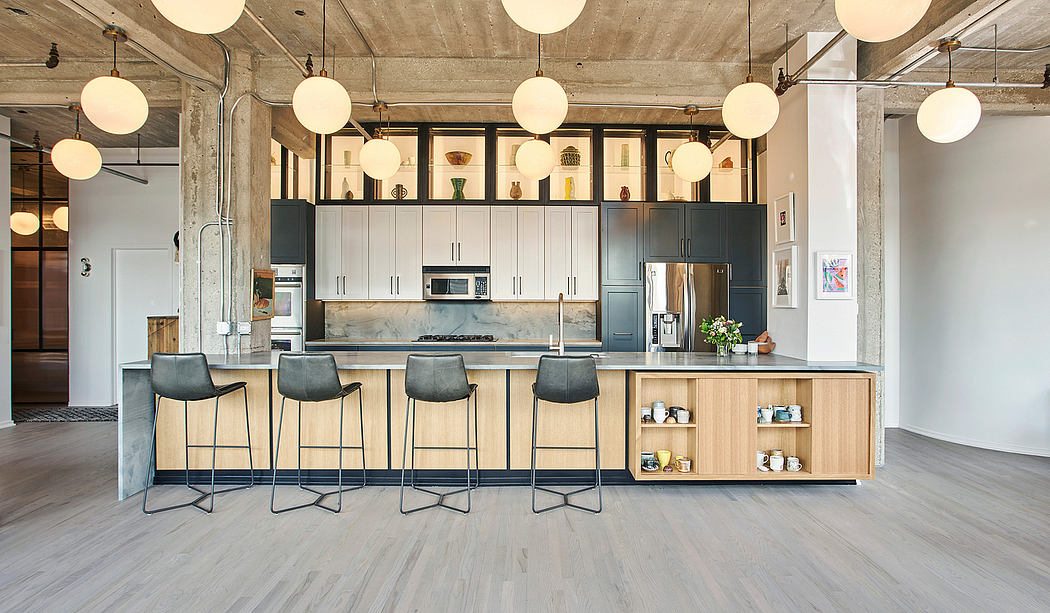 Spacious loft-style kitchen with modern cabinetry, pendant lights, and concrete ceiling.