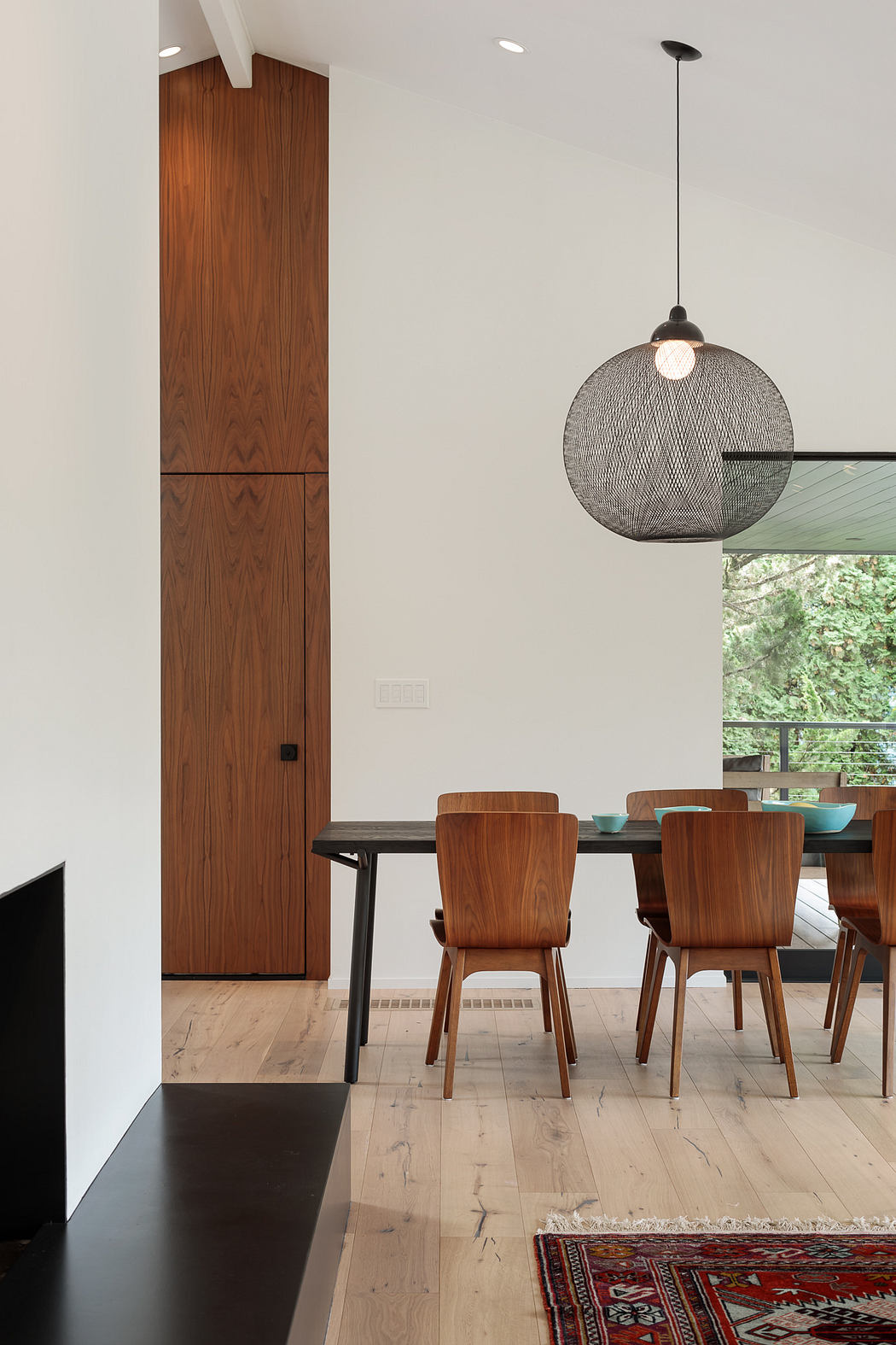 Modern, minimalist dining space with wooden furniture, pendant light, and natural wood accents.