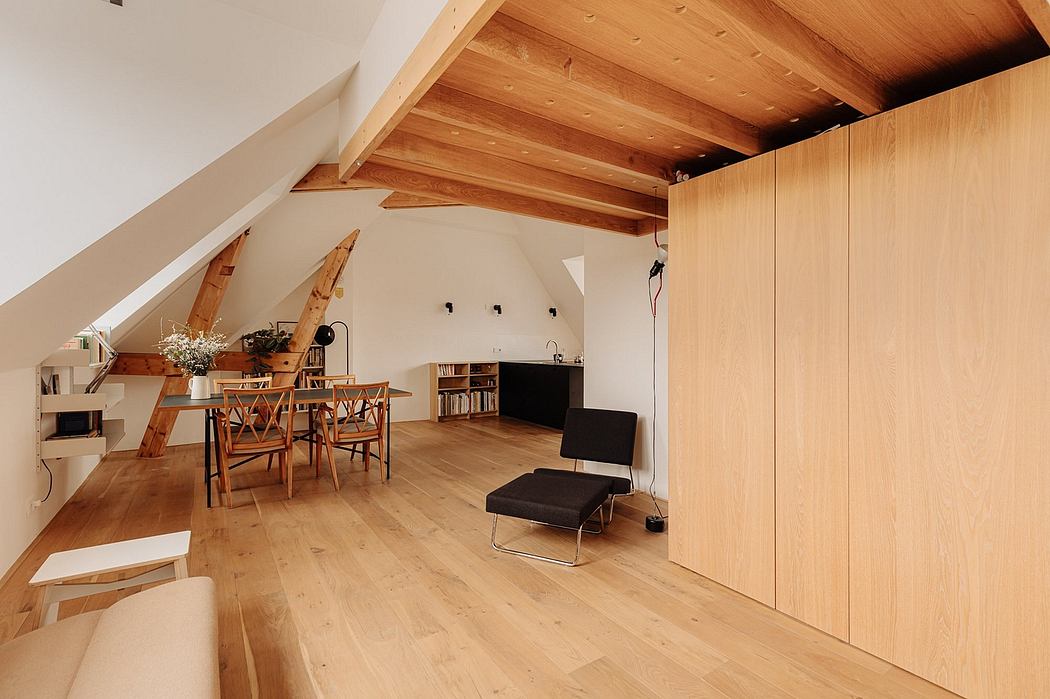 Cozy attic room with exposed wooden beams, wooden floor, and modern furnishings.