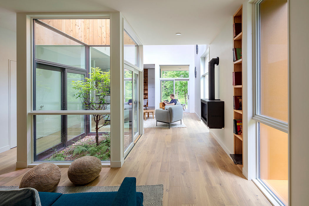 Spacious modern interior with large windows, wood floors, and natural decor elements.