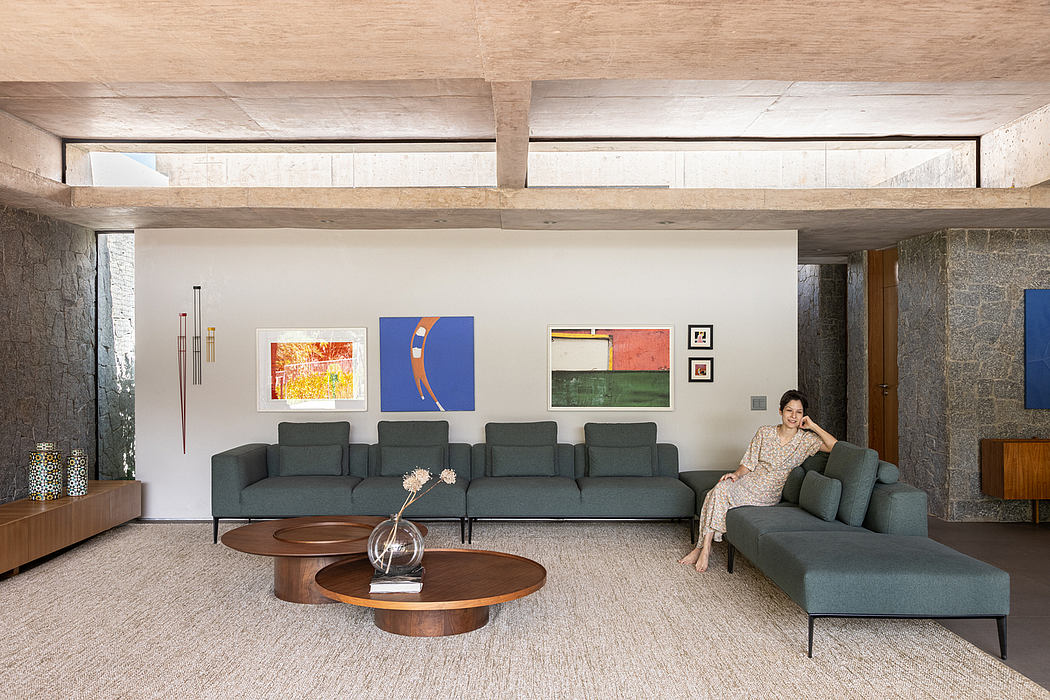 A cozy, modern living space with wooden beams, colorful artwork, and comfortable seating.