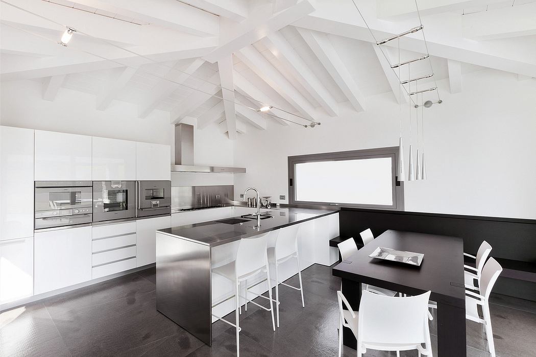 A modern, minimalist kitchen with sleek stainless steel appliances and an open, airy design.