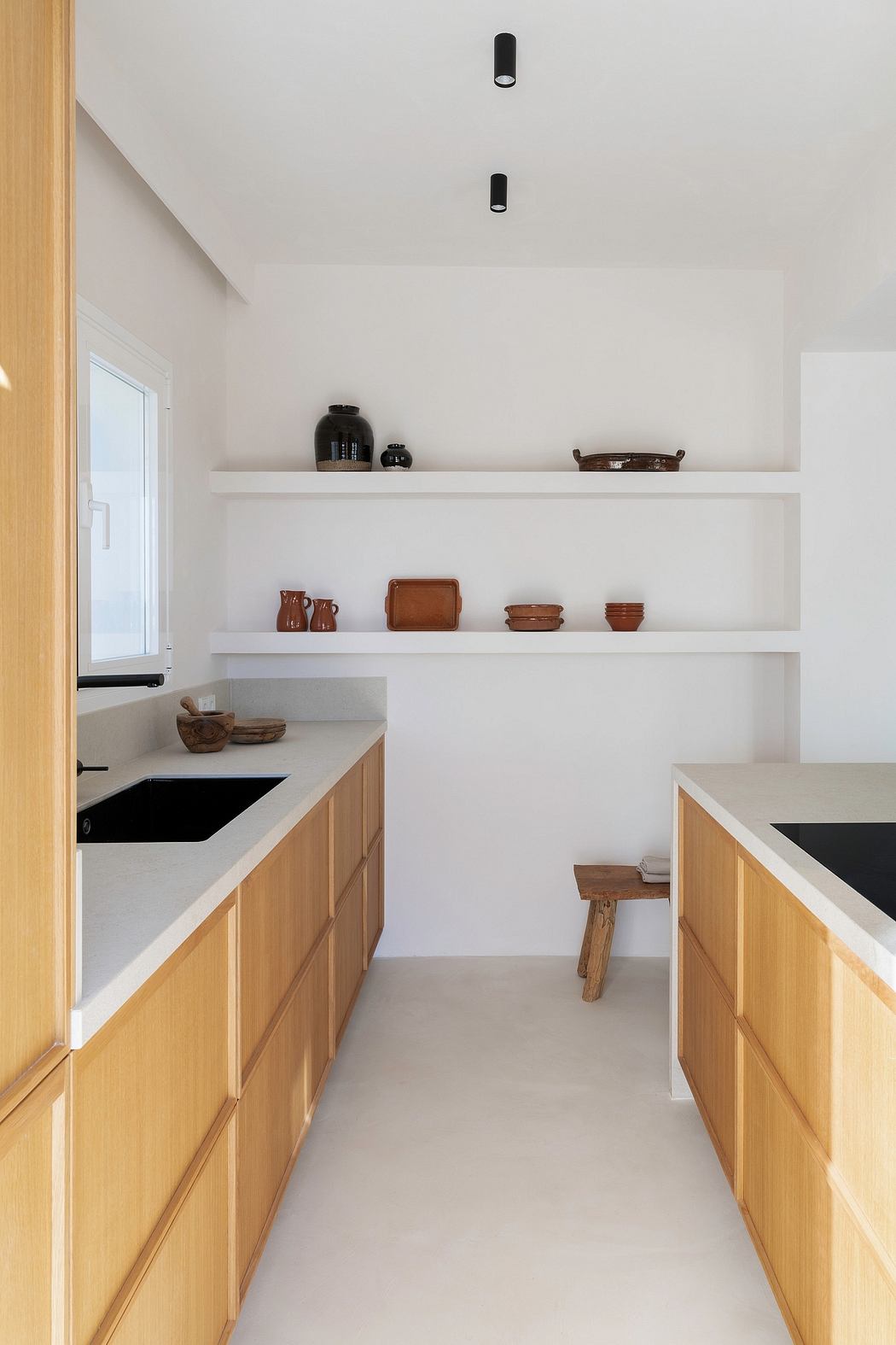 Minimalist kitchen with white shelves, wood cabinets, and recessed lighting.