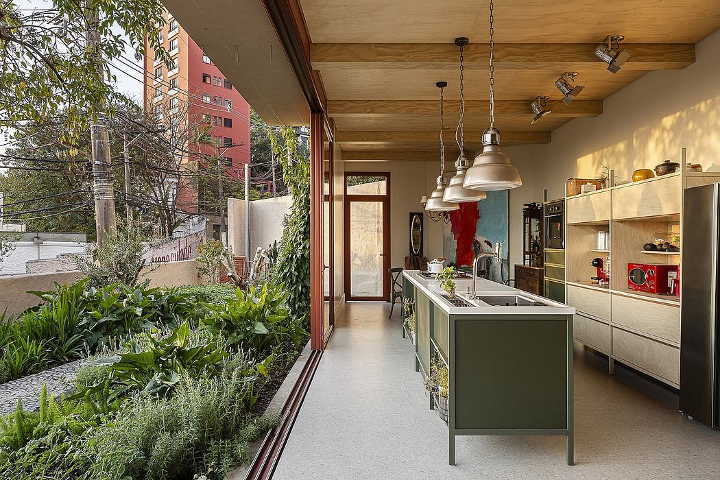 A modern, open-concept kitchen with wood-paneled ceilings, pendant lights, and a garden view.