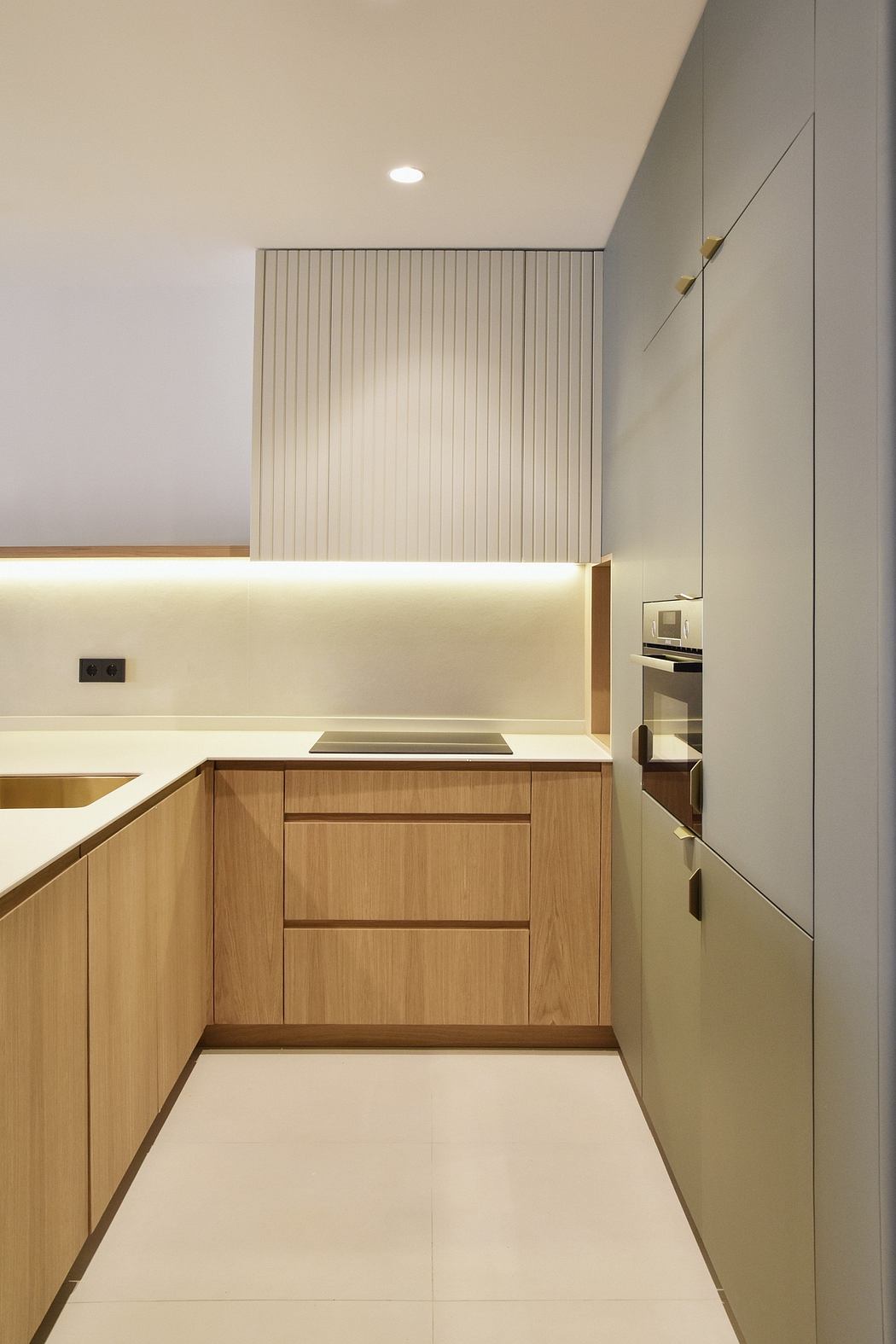 A modern kitchen with clean lines, wood cabinetry, and recessed lighting.